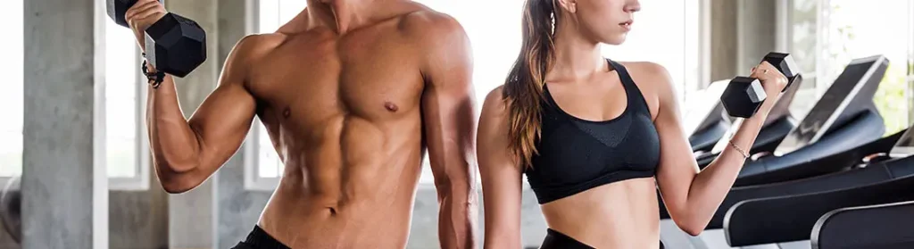 fit man and woman posing with dumbbells